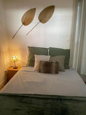 a bed with two umbrellas on the wall at Narbonne : Logement idéalement situé in Narbonne