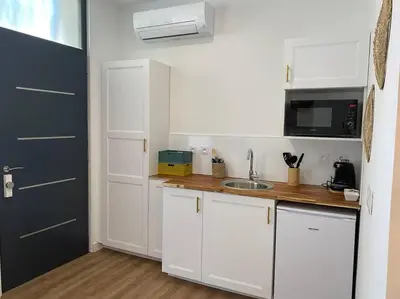a small kitchen with white cabinets and a sink at Narbonne : Logement idéalement situé in Narbonne