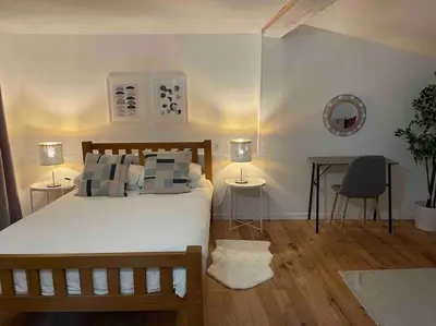 a bedroom with a bed and a desk with two lamps at Elegant and Charming Townhouse with roof terrace in Limoux
