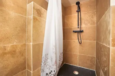 a shower with a white shower curtain in a bathroom at Les Remparts in Carcassonne
