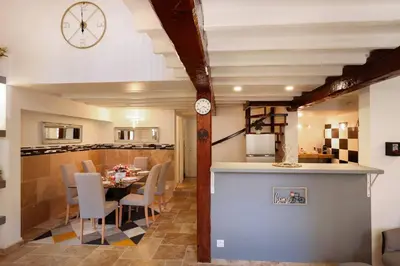 a kitchen and dining room with a table and a clock at Les Remparts in Carcassonne