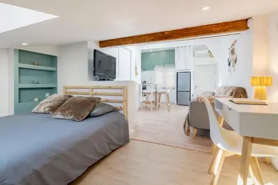 a bedroom with a bed and a desk at Charmant studio plein centre des couverts, calme et climatisé in Mirepoix