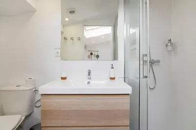 a bathroom with a white sink and a shower at Charmant studio plein centre des couverts, calme et climatisé in Mirepoix