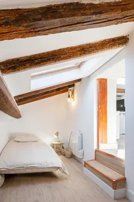 a bedroom with white walls and a bed and a window at Charmant studio plein centre des couverts, calme et climatisé in Mirepoix