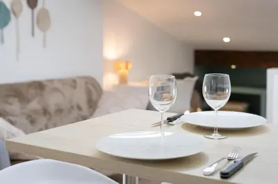 a table with two wine glasses and plates on it at Charmant studio plein centre des couverts, calme et climatisé in Mirepoix
