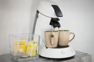 a blender sitting on top of a table with a cup at Charmant studio plein centre des couverts, calme et climatisé in Mirepoix