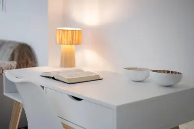 a table with a book and a lamp on it at Charmant studio plein centre des couverts, calme et climatisé in Mirepoix