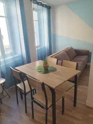 a table and chairs in a living room with a couch at Jolie T3 avec terrasse in Carcassonne