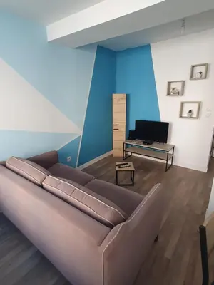 a living room with a brown couch and a television at Jolie T3 avec terrasse in Carcassonne