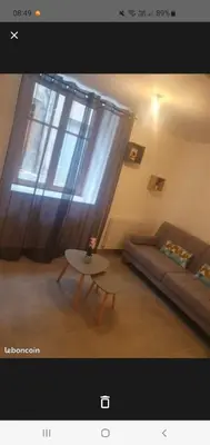 a living room with a couch and a table and a window at Jolie T2 en rez de chaussée in Carcassonne