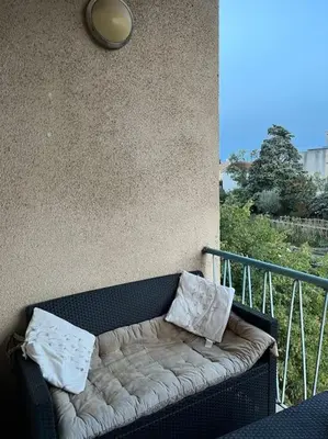 a bench against a wall with two pillows on it at Appartement 2 chambres narbonne in Narbonne
