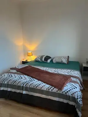 a bedroom with a bed in a white room at Appartement 2 chambres narbonne in Narbonne