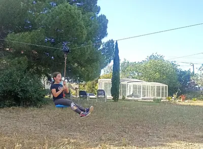a woman sitting on a swing in a park at Mas des 2 paons in Villedaigne