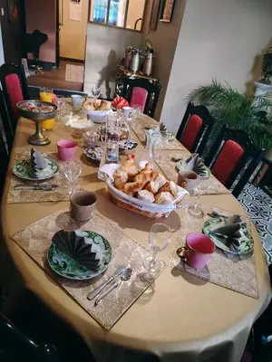 a table with plates and glasses and a bowl of food at Mas des 2 paons in Villedaigne
