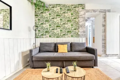 a living room with a couch and two tables at Le Nid - tout à pied - Wifi in Carcassonne