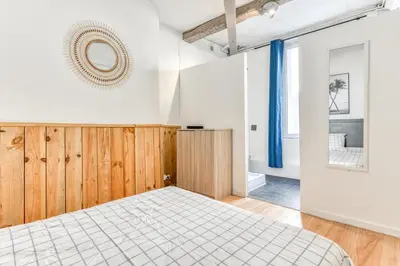 a bedroom with a bed and a mirror on the wall at Le Nid - tout à pied - Wifi in Carcassonne