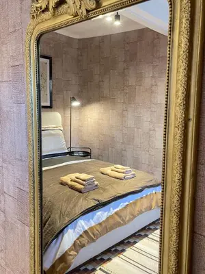 a mirror reflection of a bed in a bedroom at Maison Petit Arago avec roof terrace et parking privé in Carcassonne