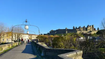 a walkway with a castle in the background at Maison Petit Arago avec roof terrace et parking privé in Carcassonne