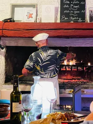 a man standing in a kitchen preparing food at Maison Petit Arago avec roof terrace et parking privé in Carcassonne