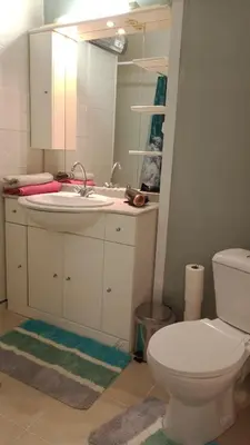 a bathroom with a toilet and a sink and a mirror at L'ombrelle in Carcassonne