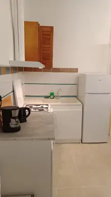 a kitchen with white cabinets and a sink and a stove at L'ombrelle in Carcassonne