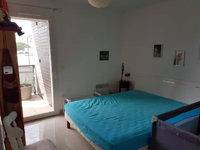 a bedroom with a bed and a large window at Location saisonnière Résidence Ephyra Gruissan in Gruissan