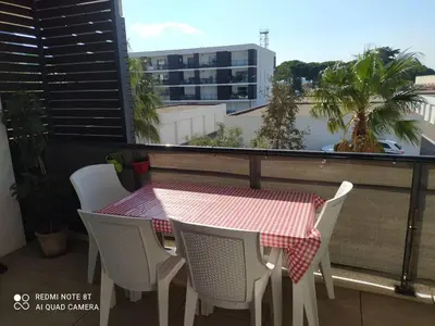 a table and chairs on a balcony with a view of a building at Location saisonnière Résidence Ephyra Gruissan in Gruissan