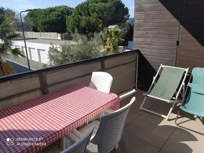 a table and chairs sitting on a balcony at Location saisonnière Résidence Ephyra Gruissan in Gruissan