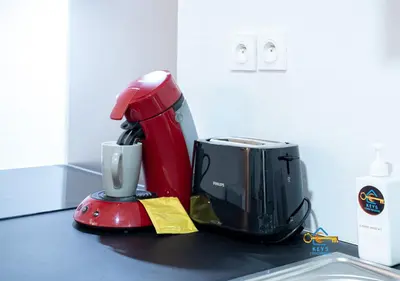 a kitchen counter with a sink and a red appliance at Au soleil levant*terrasse*Local à vélo*oc keys in Castelnaudary
