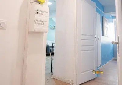 a hallway with white walls and a wooden floor at Au soleil levant*terrasse*Local à vélo*oc keys in Castelnaudary