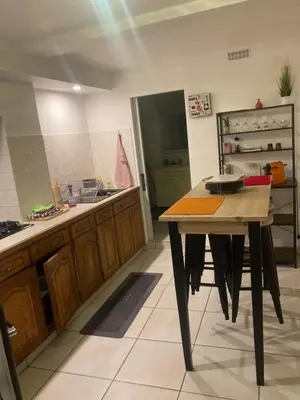 a kitchen with a table in the middle of a room at Appartement à deux pas du centre ville in Limoux