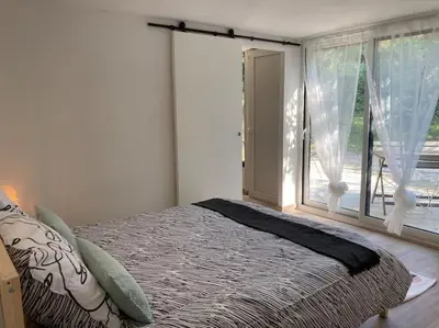 a bedroom with a bed and a large window at Plein cœur de la nature ~ Jacuzzi Privé 24h/24h in Ventenac-Cabardès