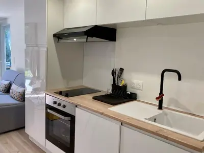 a white kitchen with a sink and a stove at Plein cœur de la nature ~ Jacuzzi Privé 24h/24h in Ventenac-Cabardès