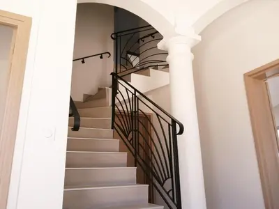 a spiral staircase in a house with white columns at Trois appartements au sein du Mas Jams - Le Gouleyrous, Le Canigou et Le Figarassa in Vingrau