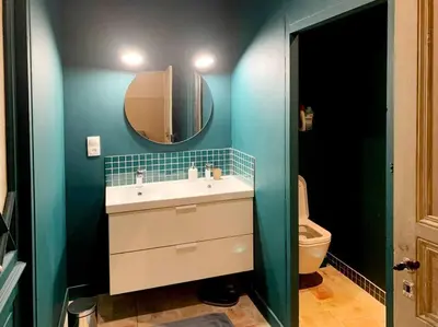 a bathroom with a sink and a mirror and a toilet at La Grande Traverse gîte d'exception de bord de mer in Lapalme