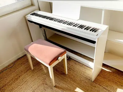 a white piano with a stool next to it at La Grande Traverse gîte d'exception de bord de mer in Lapalme