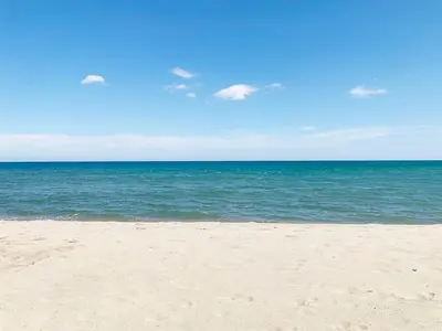 a sandy beach with the ocean in the background at La Grande Traverse gîte d'exception de bord de mer in Lapalme