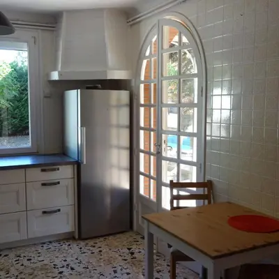 a kitchen with a refrigerator and a table and a window at Ty Calon Lan in Montazels