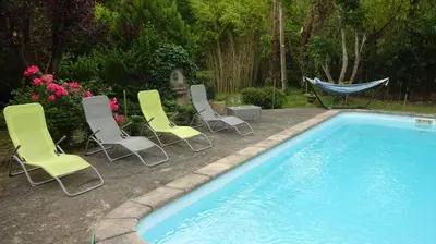 a group of chairs and a hammock next to a pool at Ty Calon Lan in Montazels