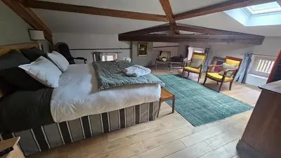 a bedroom with a large bed and a living room at L'HORTE in Revel