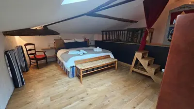 a bedroom with a bed and a table and a chair at L'HORTE in Revel