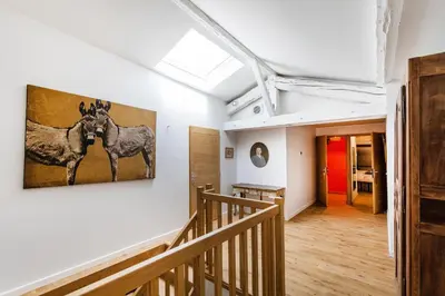 a hallway with a painting of two horses on the wall at L'HORTE in Revel