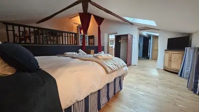 a bedroom with a large bed and a wooden floor at L'HORTE in Revel