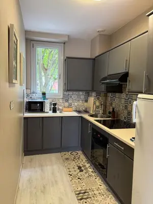a kitchen with gray cabinets and a window at Le carré Gambetta in Carcassonne