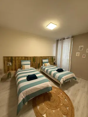 a room with two beds and a table in it at Le carré Gambetta in Carcassonne