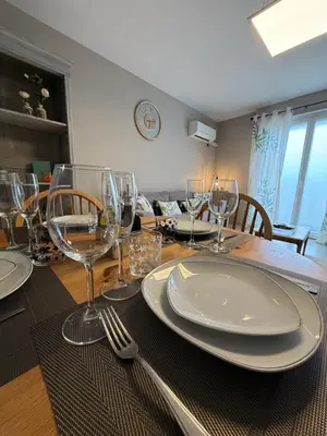 a dining room table with plates and wine glasses at Le carré Gambetta in Carcassonne