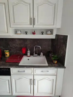 a kitchen with white cabinets and a sink at Gîte et Chambre d'hôte Entre Tilleul et Agrumes in Vinassan