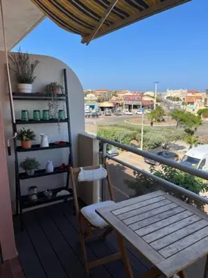 a balcony with a table and a bench on a balcony at Chez Armelle in Port-la-Nouvelle