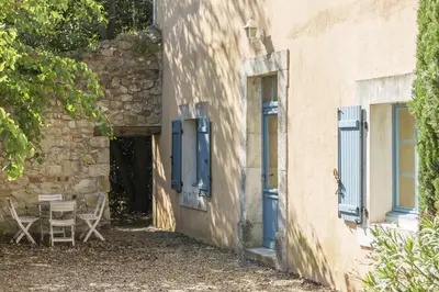 a building with blue doors and a table and chairs at Château Pech-Celeyran in Salles-dʼAude