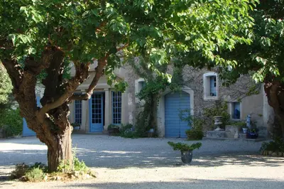 a house with a blue door and a tree at Château Pech-Celeyran in Salles-dʼAude